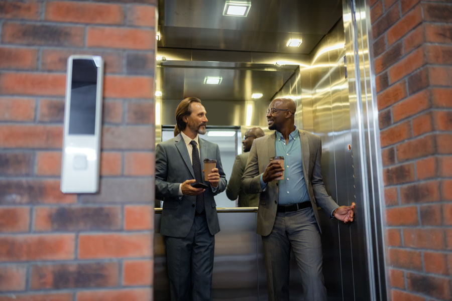 Two men stepping out of an elevator